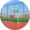 Round image of green basketball hoop with clear backboard on a red court with blue skies